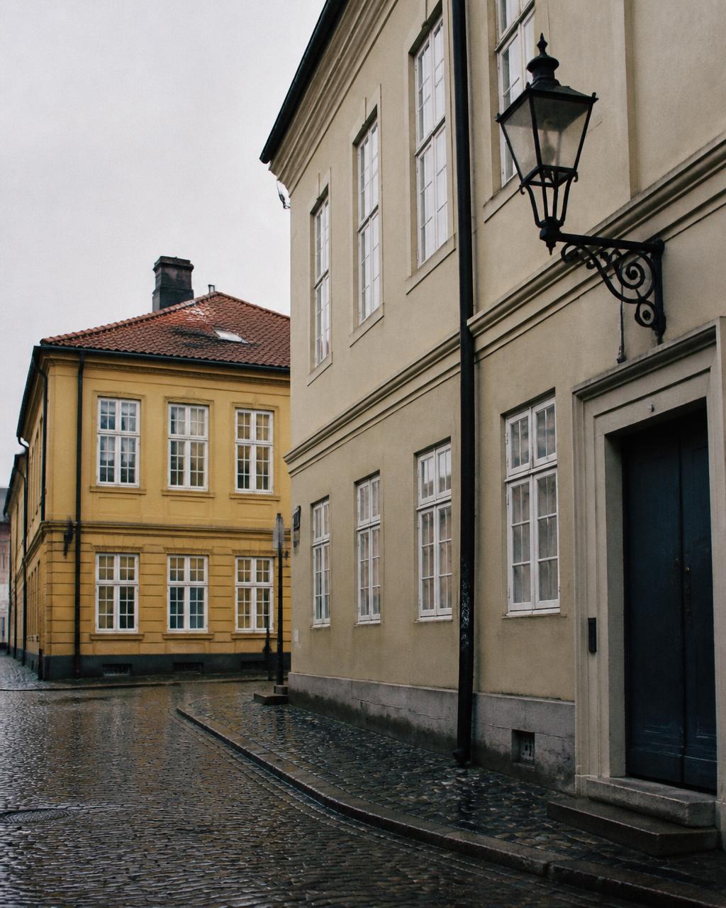 Cobblestones and yellow facades in Kvadraturen, Oslo, on a rainy day